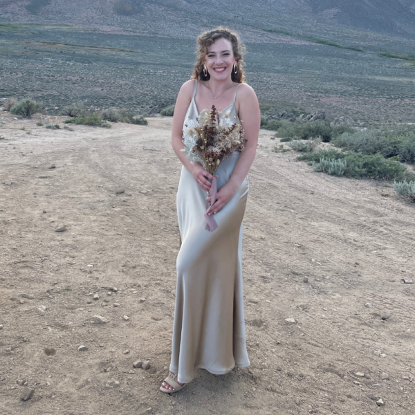 Gold dress and woman with flowers standing out in nature